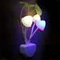 A vibrant LED mushroom night light plugged into a wall socket.