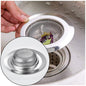 Close-up of a shiny stainless steel sink strainer showing its full hole pattern.