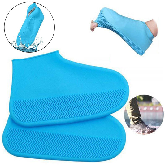 A pair of blue silicone rain boot covers with textured soles, one shown being stretched over a foot, and another in a puddle.