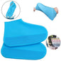 A pair of blue silicone rain boot covers with textured soles, one shown being stretched over a foot, and another in a puddle.