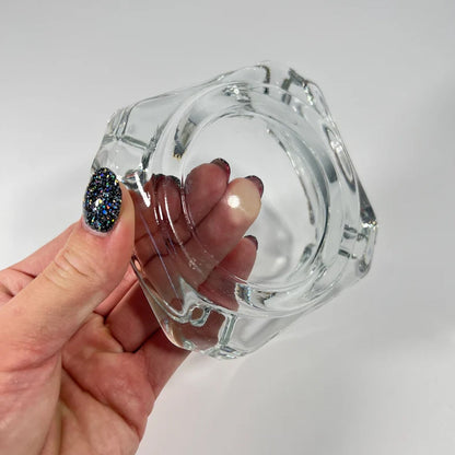 Durable crystal glass ashtray suitable for outdoor use on a patio table.