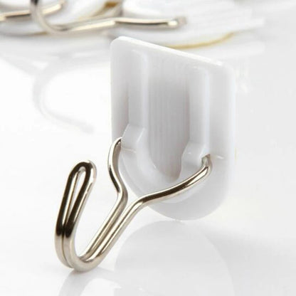 White self-adhesive wall hook for hanging kitchen towels.