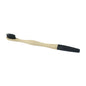 Bamboo toothbrush with soft charcoal bristles on a wooden handle
