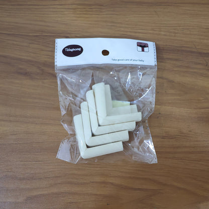 Child's hand near a table with a soft foam corner protector for safety