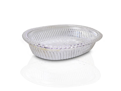 Close-up of a decorative oval silver tray with intricate royal patterns.