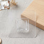 Self-adhesive transparent wall hook on a white background.