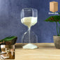 Clear glass hourglass timer with white sand showing elegant design for desk decor