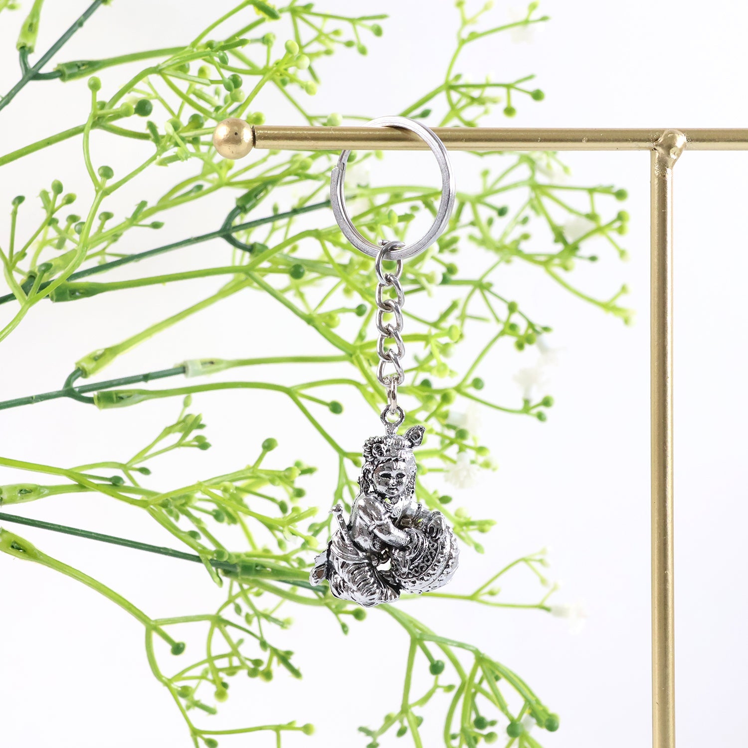 Angled view highlighting silver finish on Bal Krishna Makhan Chor metal keychain