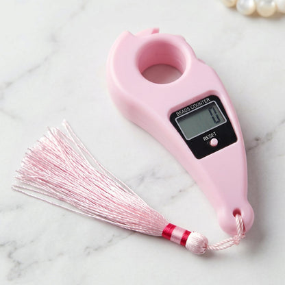 Close-up of pink digital mantra jaap counter with button and LCD screen pooja accessories