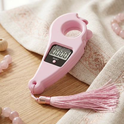 Close-up of digital mantra counter showing LCD screen and button pooja accessories