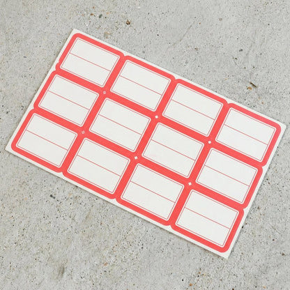 Close-up view of red and white rectangular self-adhesive label stickers
