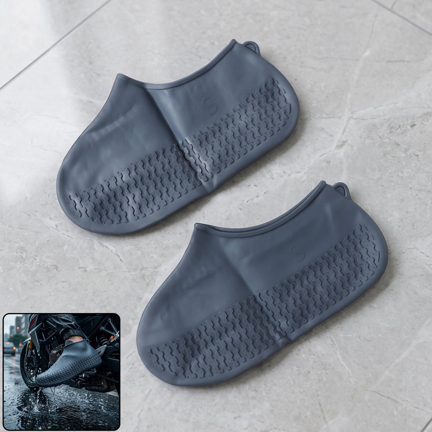 Two gray silicone shoe covers with textured soles lie on a light gray tiled floor, with an inset of a person wearing one on