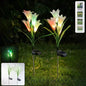 Set of two solar garden flower lights glowing with multicolour LEDs in outdoor setting