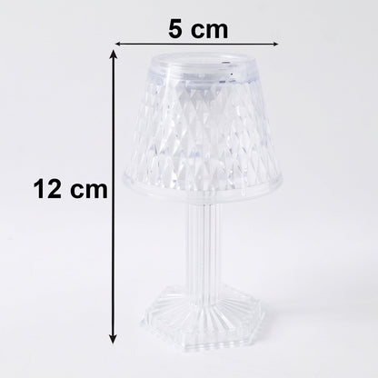 Small crystal table lamp creating a warm, ambient glow in a dark room.