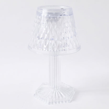 Modern LED crystal lamp displayed on a wooden shelf in a home setting.