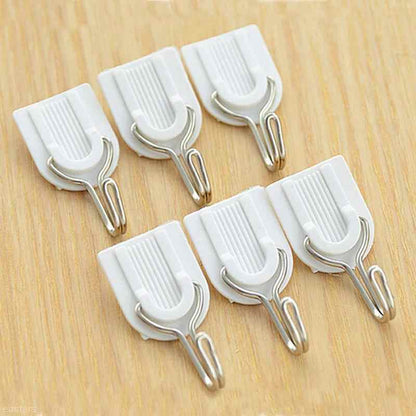 Self-adhesive hook blending seamlessly on a white tiled bathroom wall.