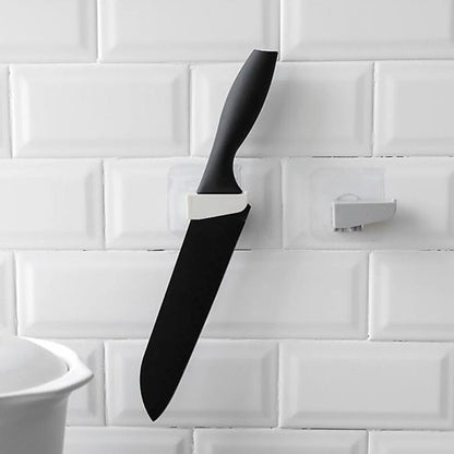 A sleek black punch-free wall hanging knife holder mounted on a kitchen wall, showcasing its modern design and space-saving functionality.