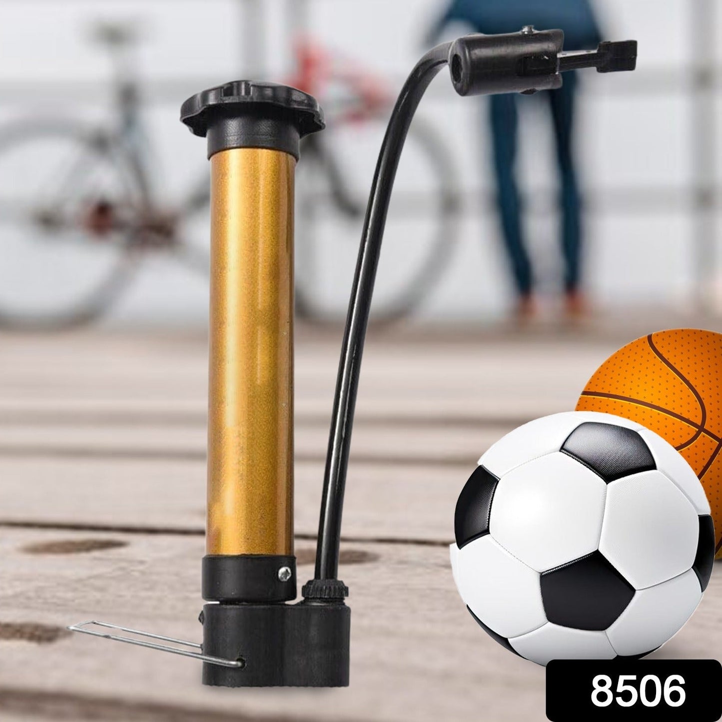 Compact metal hand air pump inflating a basketball on a court.