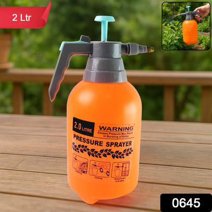 Person using a handheld garden sprayer to water outdoor plants.